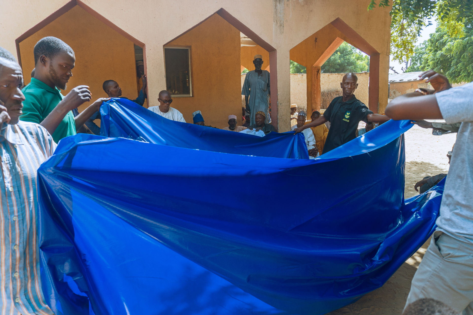 Whitesands Agro distributing drying tarpaulins to farming community